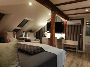 ein Schlafzimmer mit einem Bett, 2 Stühlen und einem TV in der Unterkunft AnaCapri Gästehaus Lugano in Ueckermünde