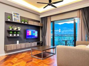 a living room with a couch and a tv and a table at Vista Residences Genting Highlands Free WiFi & 1 Parking in Genting Highlands