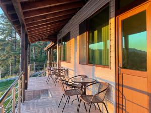 una veranda con tavoli e sedie su una casa di Villa Siesta Dospat a Dospat