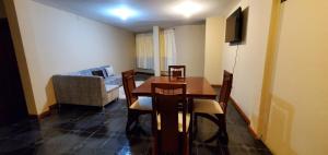 a dining room with a table and chairs and a couch at Departamento en Cuenca, 2 habitaciones y parqueo gratis in Cuenca