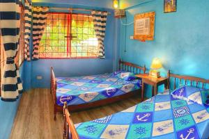 a bedroom with two beds and a window at Beach House-Casita in Calatagan with pool ( for 6) in Calatagan