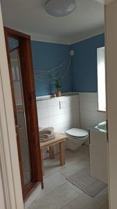 a blue bathroom with a toilet and a sink at FeWo mit Heimatgefühl in Ratekau