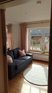 a living room with a blue couch and a window at FeWo mit Heimatgefühl in Ratekau