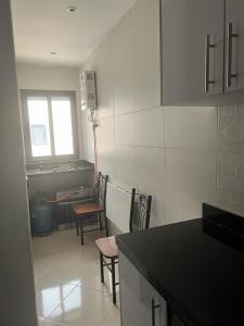 Ideal appartement de vacances في Plage de Mehdia: مطبخ فيه كرسيين وطاولة