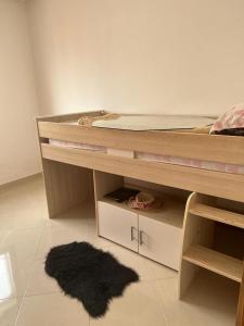 Ideal appartement de vacances في Plage de Mehdia: غرفة نوم مع سرير بطابقين مع سجادة سوداء
