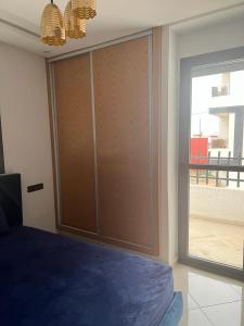 Ideal appartement de vacances في Plage de Mehdia: غرفة نوم مع باب منزلق كبير مع نافذة