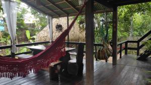 a hammock on the deck of a house at Recanto Shanti in Alter do Chao
