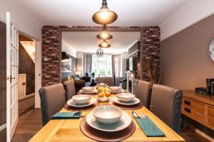 uma sala de jantar com uma mesa de madeira com cadeiras em Cheerful 3-bedroom Douglas house with patio em Southampton