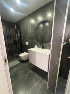 een badkamer met een wastafel, een toilet en een spiegel bij Meital house in Bat Yam