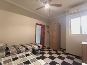 een slaapkamer met een bed en een plafondventilator bij Poseidons Seaview Penthouse in Marsalforn