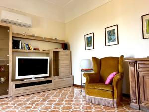 a living room with a chair and a television at Villa Catenacci Anacapri in Anacapri
