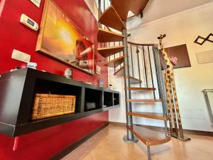 uma escada em espiral num quarto com uma parede vermelha em JAZZ House ROMA! em Infernetto