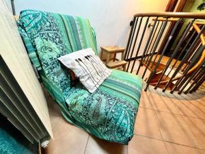 um sofá verde com uma almofada em cima em JAZZ House ROMA! em Infernetto