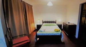 1 dormitorio con 1 cama y 1 silla en Departamento Céntrico Amplio en Salta