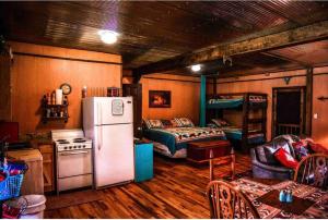 a kitchen with a refrigerator and a bed in a room at Caddo Cabin on Collier Creek in Norman
