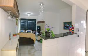 una cocina con armarios blancos y una mesa en una habitación en Apartamento Confortável!, en Maceió