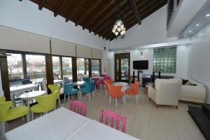 a dining room with colorful chairs and tables at Dardanos Pension in Hamidiye