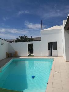 a swimming pool in front of a white house at Lemon tree in Tías