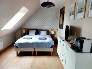 a bedroom with a bed and a tv in it at Chambres d'hôtes chez l'habitant - Bed & Breakfast homestay in Huisnes-sur-Mer