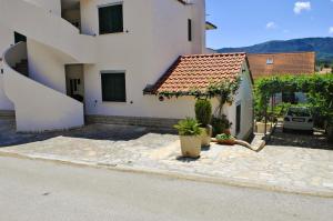 a house with a courtyard with a car parked next to it at Apartments Buljevic in Vrboska
