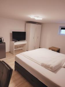 een slaapkamer met een groot bed en een televisie bij E&O in Gilching