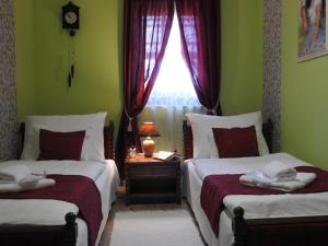 2 Betten in einem Zimmer mit grünen Wänden und einem Fenster in der Unterkunft Mözsi Apartman Tolna in Tolna