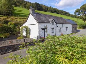 an old white house in the middle of a road at Tyn Y Ffordd in Llanymawddwy