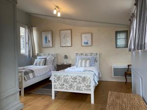 a bedroom with two beds and a table at Maison de Corinne in Bergerac