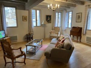 ein Wohnzimmer mit einem Sofa und einem Tisch in der Unterkunft Maison de Corinne in Bergerac