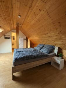 a bed in a room with a wooden ceiling at Pensionszimmer Larifari in Drees