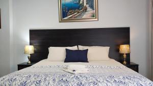 a bedroom with a bed with a black headboard and two lamps at Gemstone Guest House in Klerksdorp