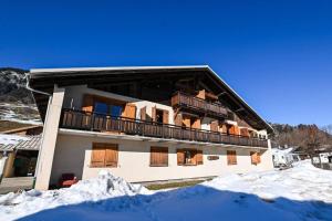 a building with a balcony in the snow at Le balcon des neiges in Praz-sur-Arly
