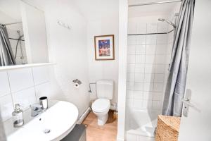 a white bathroom with a toilet and a sink at Le balcon des neiges in Praz-sur-Arly