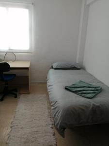 a bedroom with a bed and a desk and a window at Gibraltar Rock View in La Línea de la Concepción