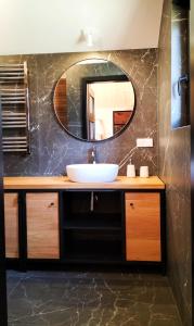 a bathroom with a sink and a mirror at Dzikie Lisko - Apartament z klimatyzacją in Lesko