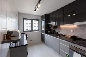 a kitchen with black and white cabinets and a window at FLH Marvila Family Apartment in Lisbon
