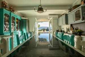 kuchnia z niebieskimi szafkami i widokiem na wodę w obiekcie Vasiliki's Villa Beach Front and Pool w mieście Porto Heli