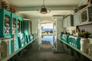 a kitchen with blue cabinets and a view of the water at Vasiliki's Villa Beach Front and Pool in Porto Heli
