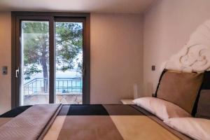 sypialnia z łóżkiem i dużym oknem w obiekcie Vasiliki's Villa Beach Front and Pool w mieście Porto Heli