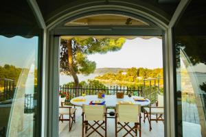 a patio with a table and chairs on a balcony at Vasiliki's Villa Beach Front and Pool in Porto Heli +119 photos