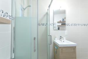 a white bathroom with a shower and a sink at Le Brivet ☆ Hypercentre ☆ Parking ☆ Terrasse in Pontchâteau +14 photos