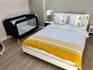 Un dormitorio con una cama grande con almohadas amarillas y blancas en Modern Living en Huningue