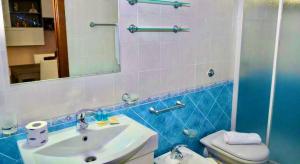 un bagno con lavandino, WC e specchio di Perla Blu a Cefalù