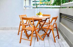 un tavolo e sedie di legno su un balcone di Perla Blu a Cefalù Altre 8 foto