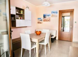 una sala da pranzo con un tavolo di legno e sedie bianche di Perla Blu a Cefalù