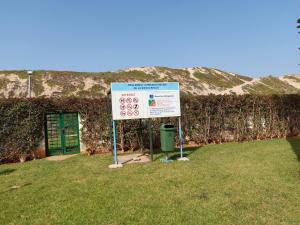 un cartel en el césped junto a una pared en Appartement au bord de l'eau, en Mohammedia