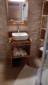 uma casa de banho com lavatório, espelho e toalhas em La CAFRINE em Cilaos