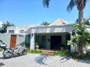 a motorcycle parked in front of a house at Bush Willow Suite - Villa Roc Guesthouse, Salt Rock Ballito Solar Power in Salt Rock
