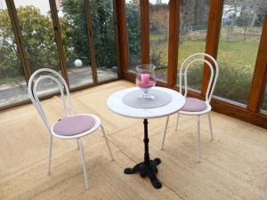 2 Stühle und ein Tisch mit einem Glas Wein darauf in der Unterkunft Ferienhaus Carolin in Heidenheim