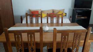una mesa de comedor con sillas y una mesa con una vela. en El Roble en Bahía Blanca